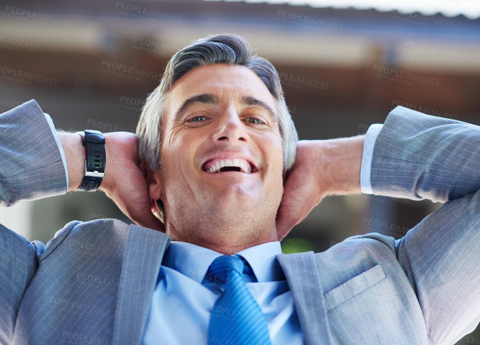 Buy stock photo Shot of a content businessman leaning back in his chair with his hands behind his head
