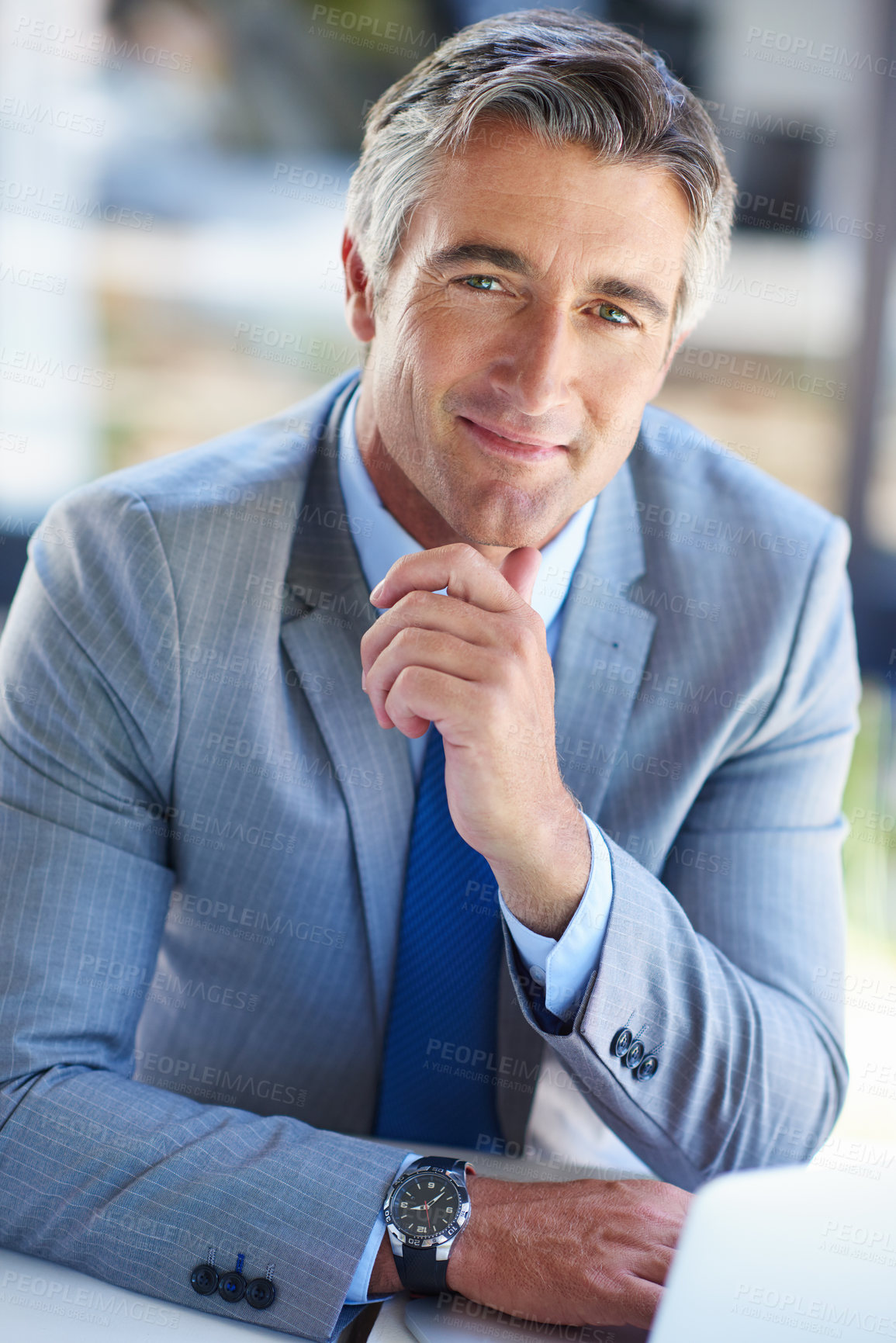 Buy stock photo Portrait of a confident-looking mature businessman working on a laptop