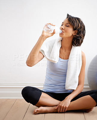 Buy stock photo Shot of a beautiful young woman enjoying a drink of water during a yoga session