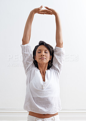 Buy stock photo Shot of a beautiful young woman stretching during a yoga session