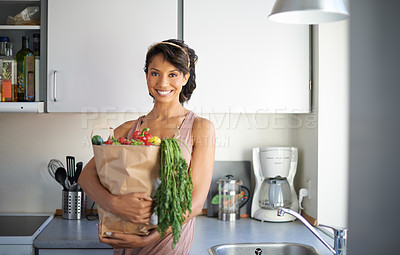 Buy stock photo Portrait of a young woman holding a paper bag of fresh produce