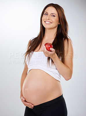 Buy stock photo Portrait, apple and pregnant with woman, smile and nutrition on a white studio background. Person, model and girl with a fruit, happiness and healthy snack with pregnancy, wellness and stomach