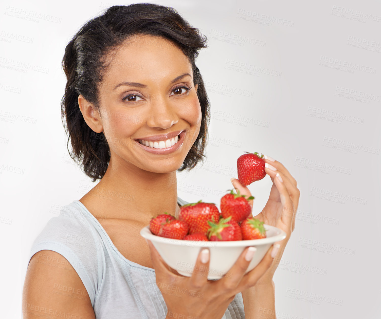 Buy stock photo Health, strawberries and portrait of woman in a studio for wellness, nutrition and organic diet. Smile, vitamins and female person from Mexico eating fruit for healthy vegan snack by gray background.