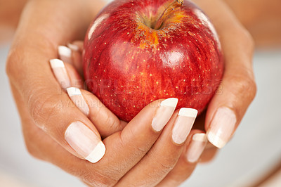 Buy stock photo Hands, apple or food with a person closeup for health, diet or nutrition in the kitchen of her home. Fruit, nutritionist and hunger with an adult eating fresh produce for a healthy weight loss snack