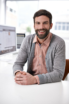 Buy stock photo Portrait of a handsome young man sitting at a desk in an office
