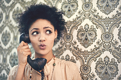 Buy stock photo Studio shot of a young woman in a vintage outfit talking on an old-fashioned telephone