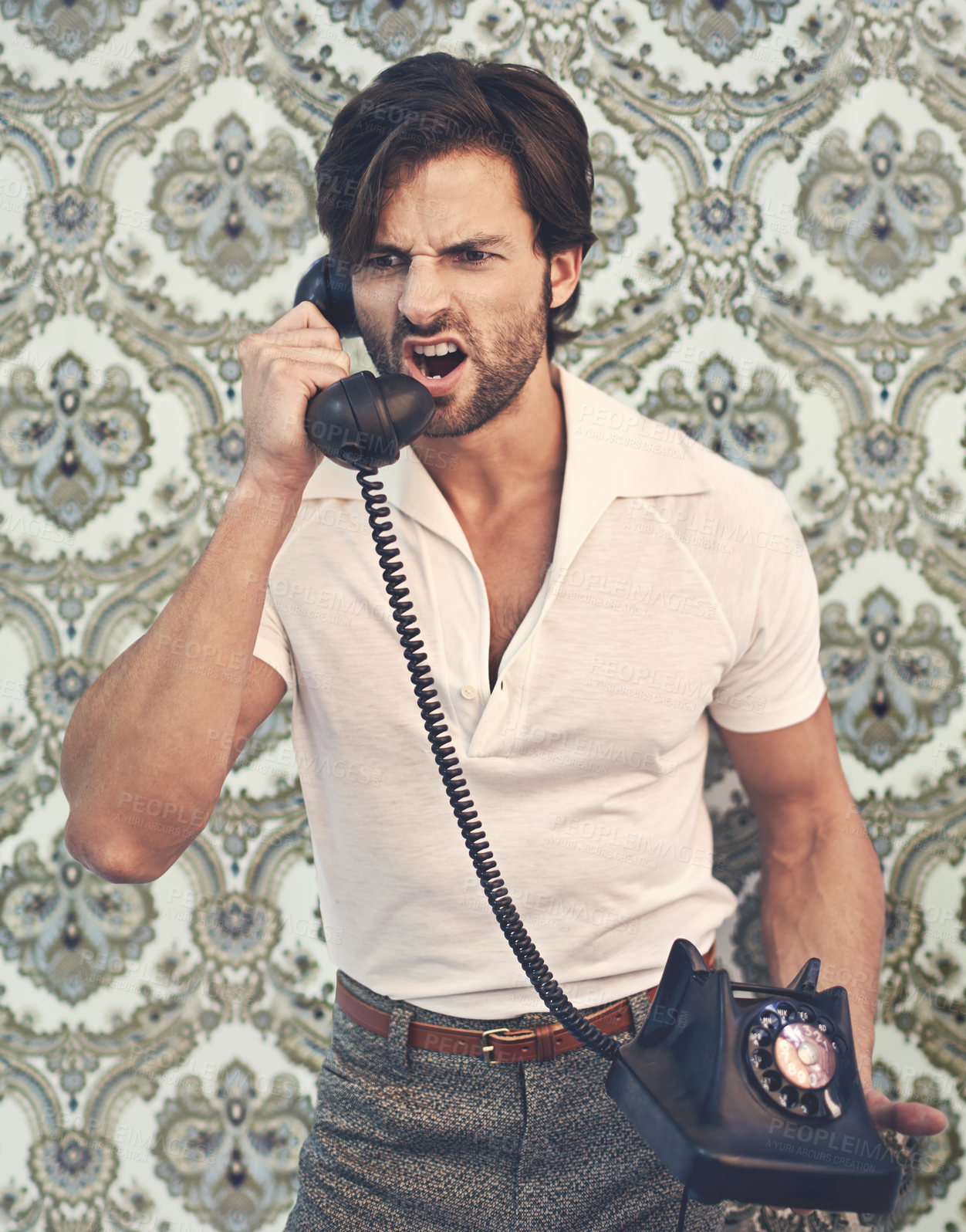 Buy stock photo A handsome man in retro 70s clothing shouting at someone on the phone