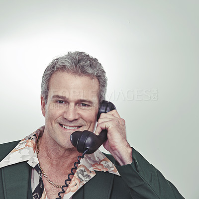 Buy stock photo Cropped studio portrait of a confident mature man talking on an old-fashioned telephone