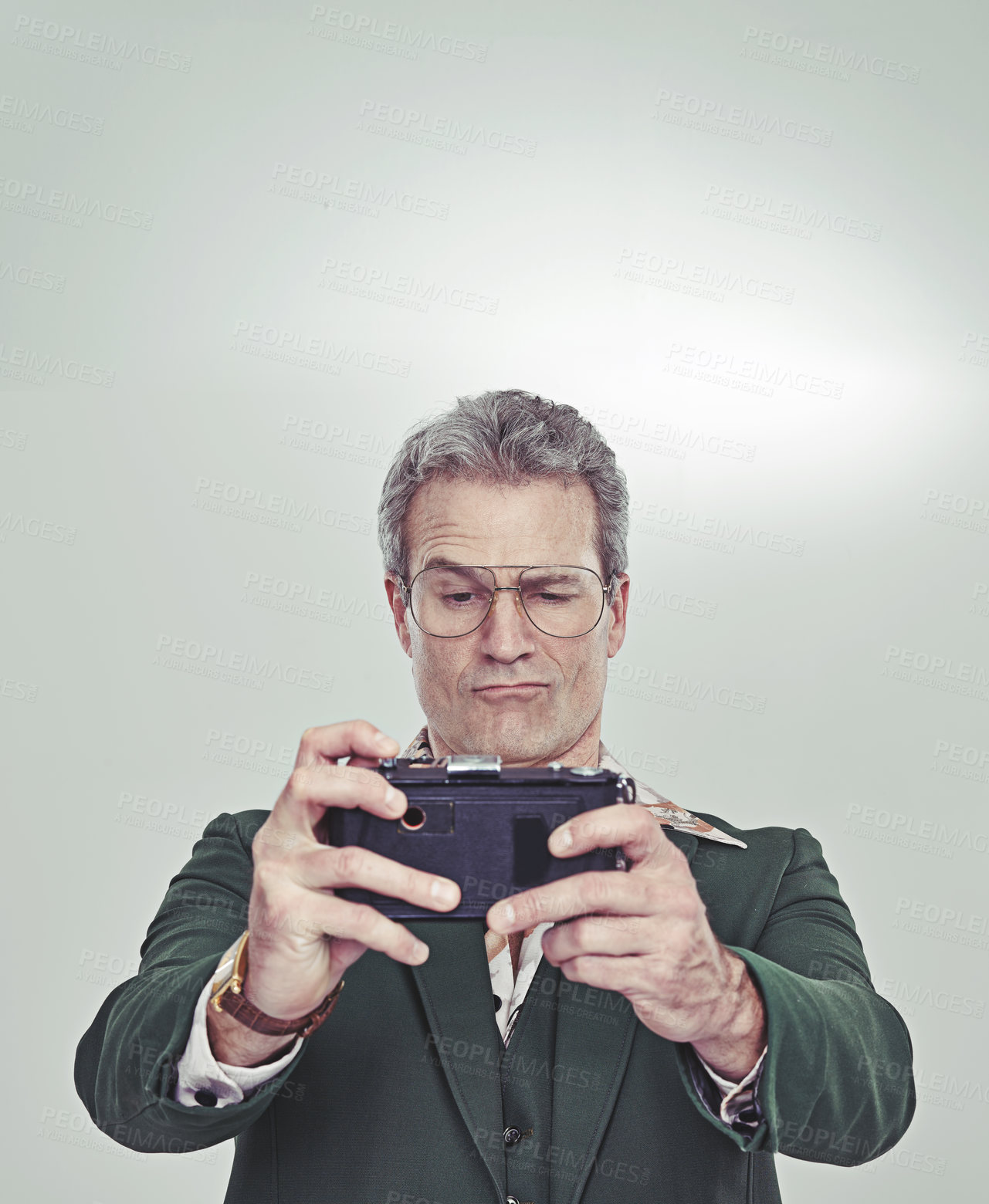 Buy stock photo Cropped studio shot of a mature man in a retro suit taking a selfie with an old-fashioned camera