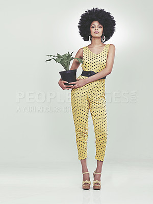 Buy stock photo Full length portrait of young woman wearing a 70s retro jumpsuit holding a potted plant