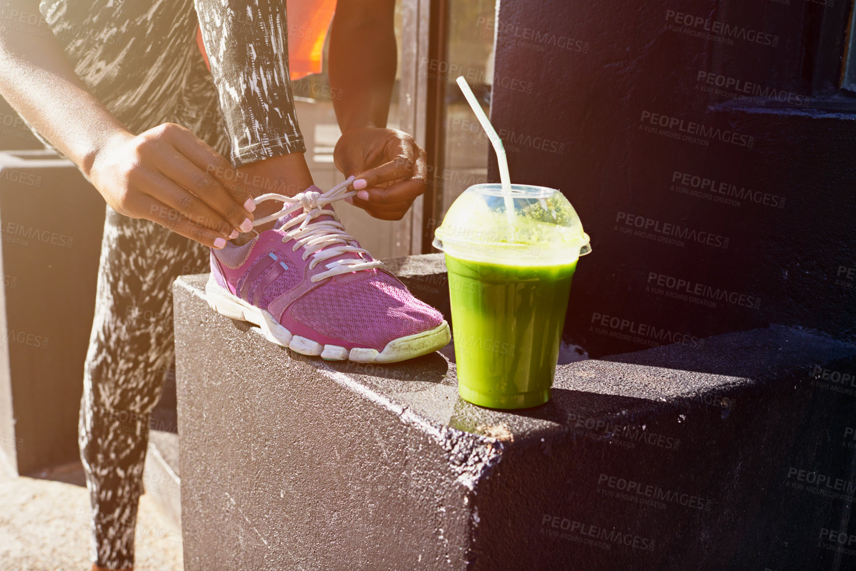 Buy stock photo Woman, hands and tying shoe with smoothie for fitness, diet or health and wellness in city. Closeup, female person or runner with drink or tie laces for workout preparation or exercise in urban town