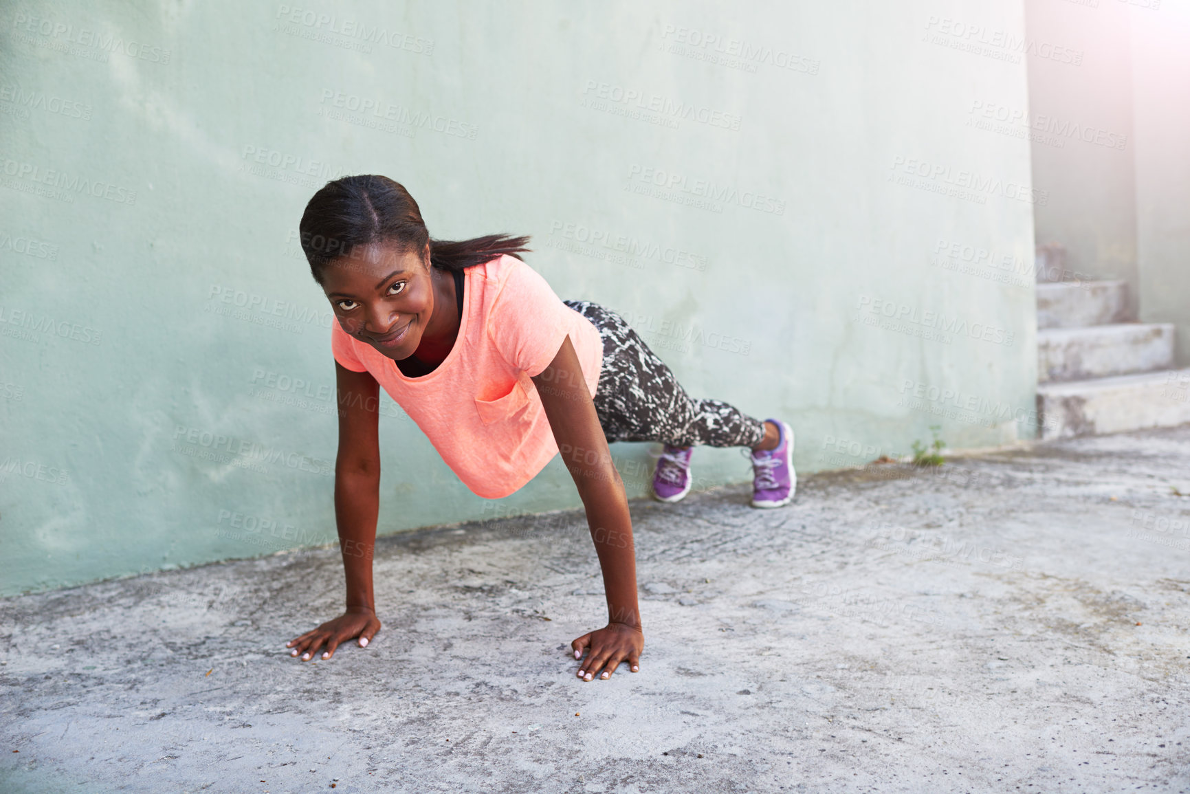Buy stock photo Happy, portrait or black woman with push ups for fitness, exericse or outdoor workout on concrete floor. Young African, female person or athlete with smile for arm plank, core strength or muscle gain