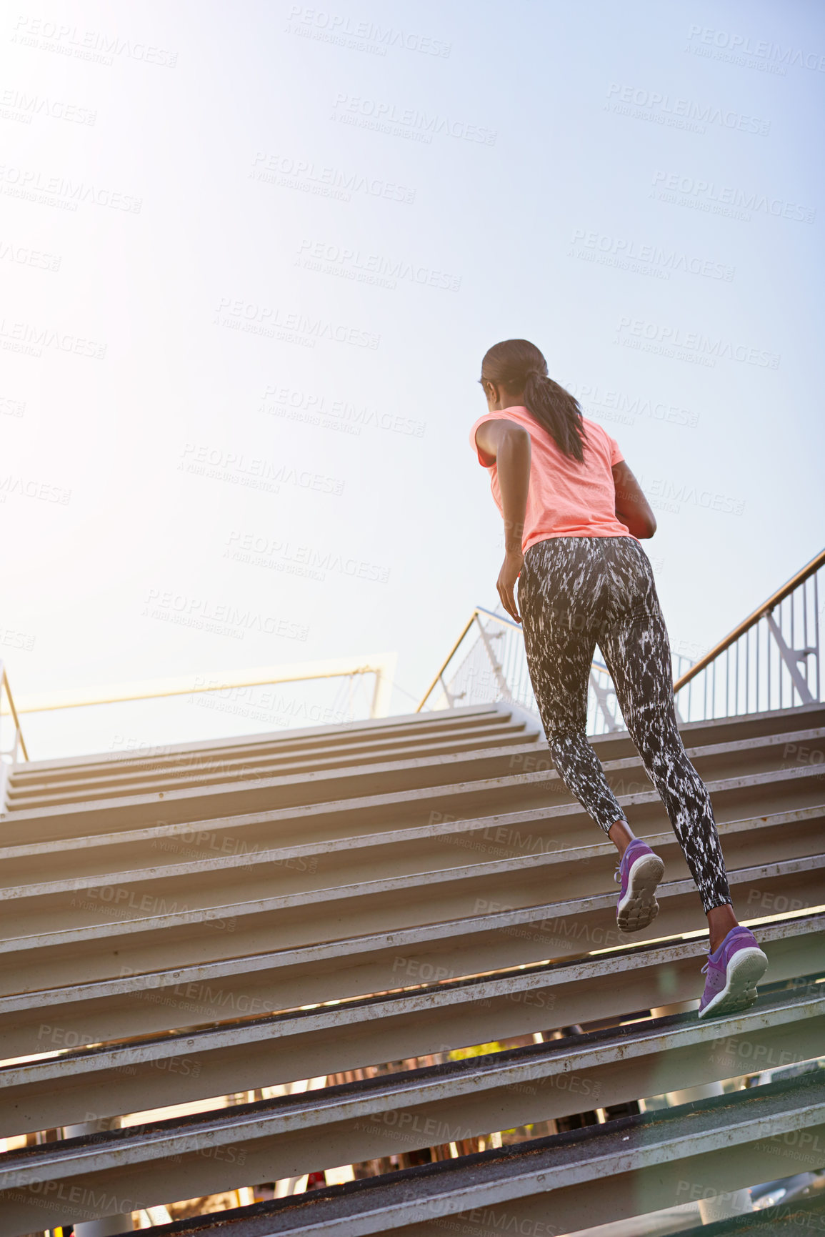 Buy stock photo Rearview shot of a young female athlete running up and down the bleachers