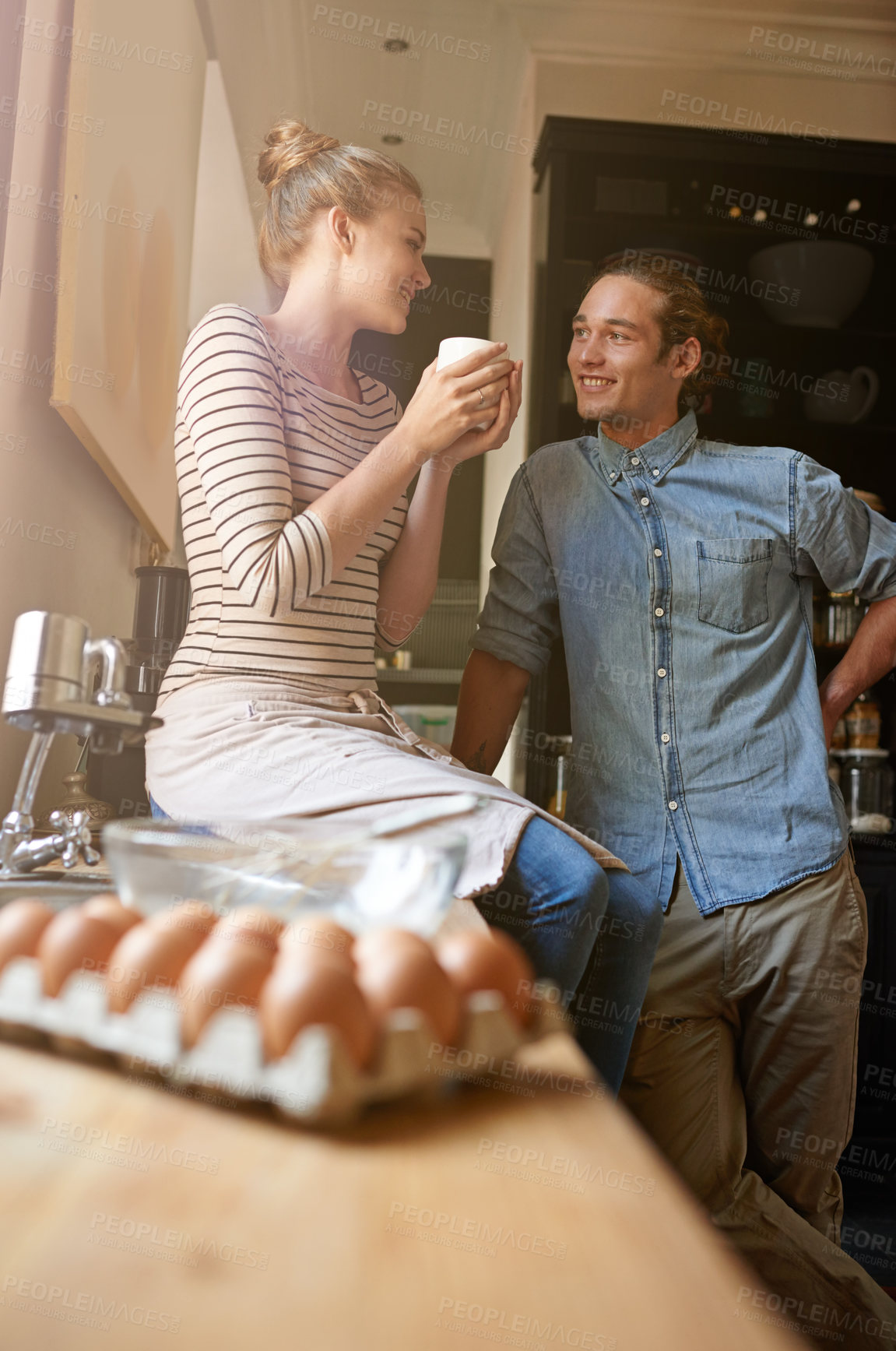 Buy stock photo Shot of a young couple bonding in the kitchen