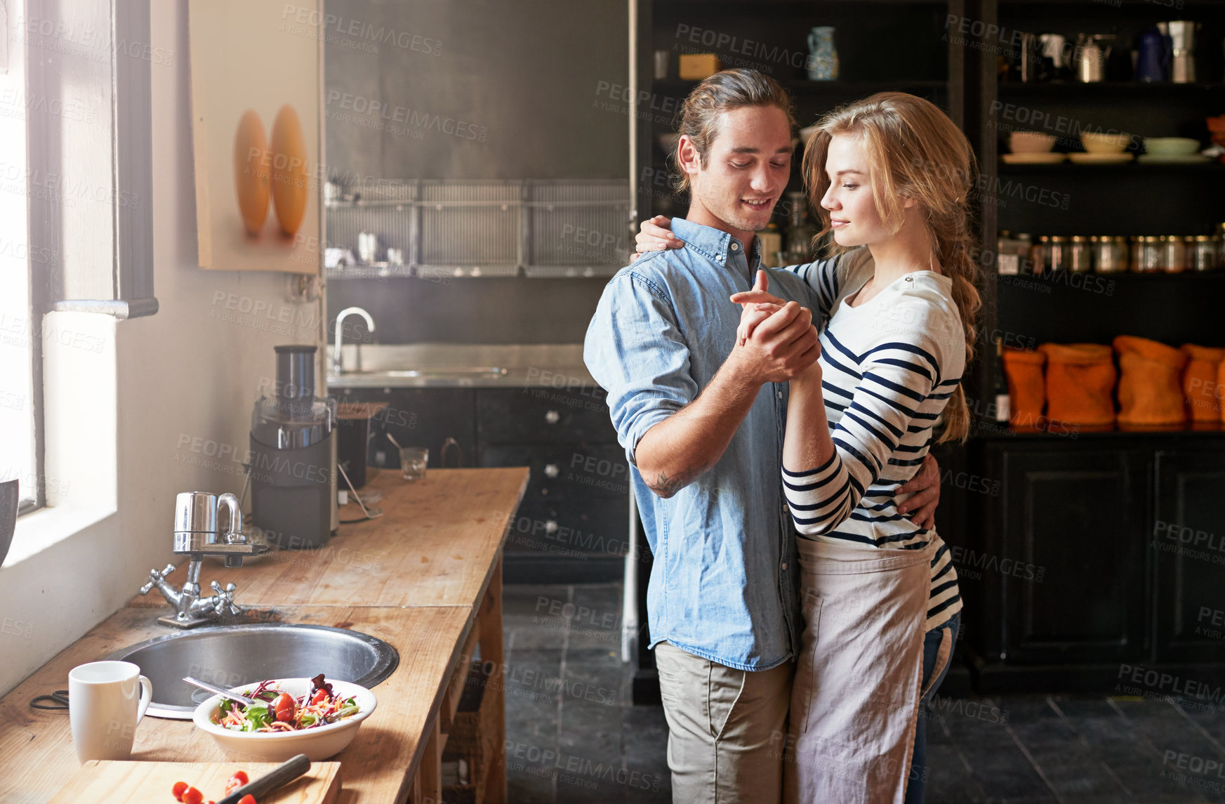 Buy stock photo Holding hands, dancing or couple with romance cooking in kitchen for food, meal prep or care. Smile, hug and people in apartment to celebrate anniversary for love at dinner, lunch or brunch in home