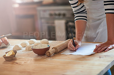 Buy stock photo Cropped shot of a woman writing a recipe for the dough that she's preparing