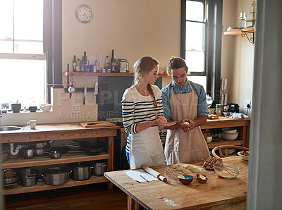 Buy stock photo Shot of a young couple making small balls of dough