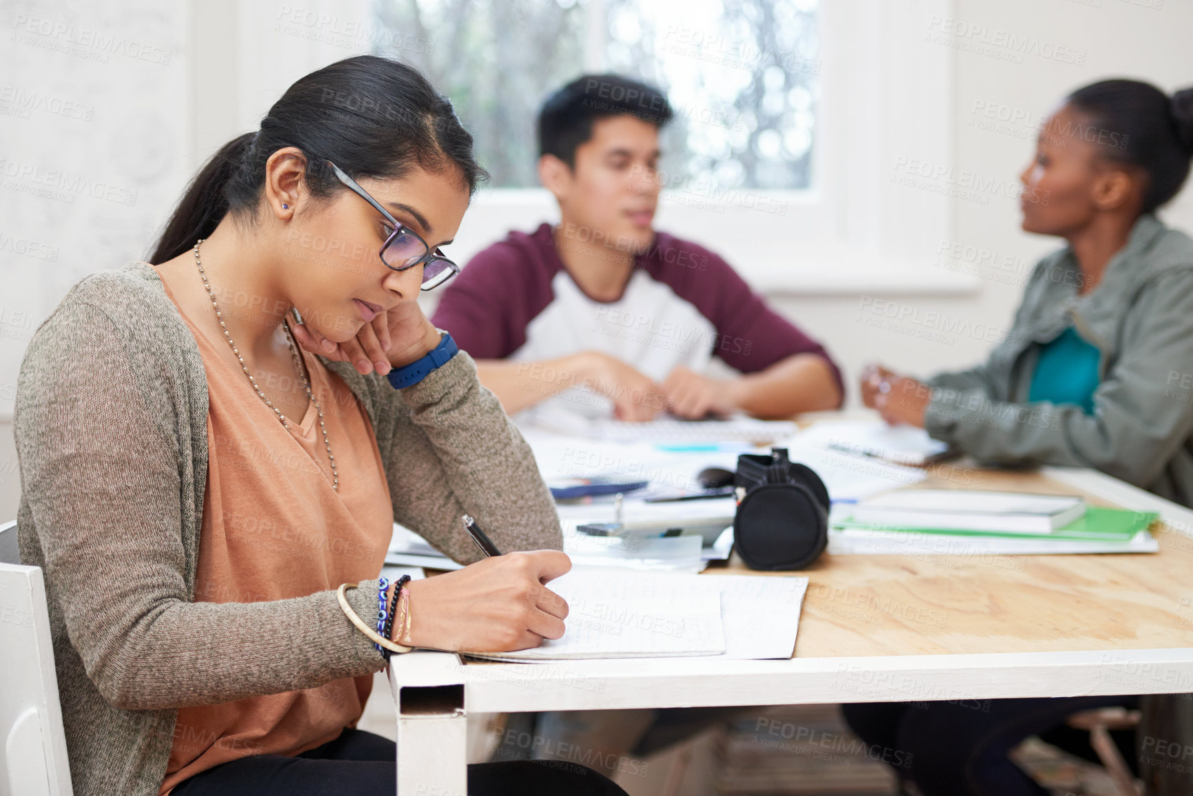 Buy stock photo Cropped shot of three university students studying