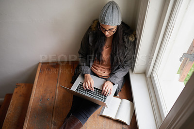 Buy stock photo A young woman using her laptop at home
