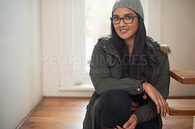 Buy stock photo A young woman sitting by the steps inside her house