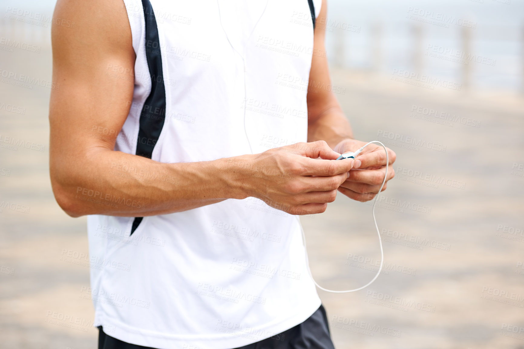 Buy stock photo Man, workout and earphones to listen to music, podcast and song on run, exercise and cardio. Male athlete, hearing and streaming radio, audio and sound by ocean, outdoors and inspiration for fitness