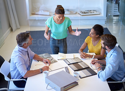 Buy stock photo Cropped shot of an attractive young businesswoman explaining her proposal to the team