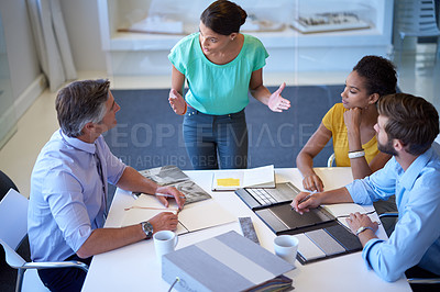Buy stock photo Cropped shot of an attractive young businesswoman explaining her proposal to the team