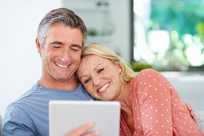 Buy stock photo Shot of a mature couple relaxing with their digital tablet at home