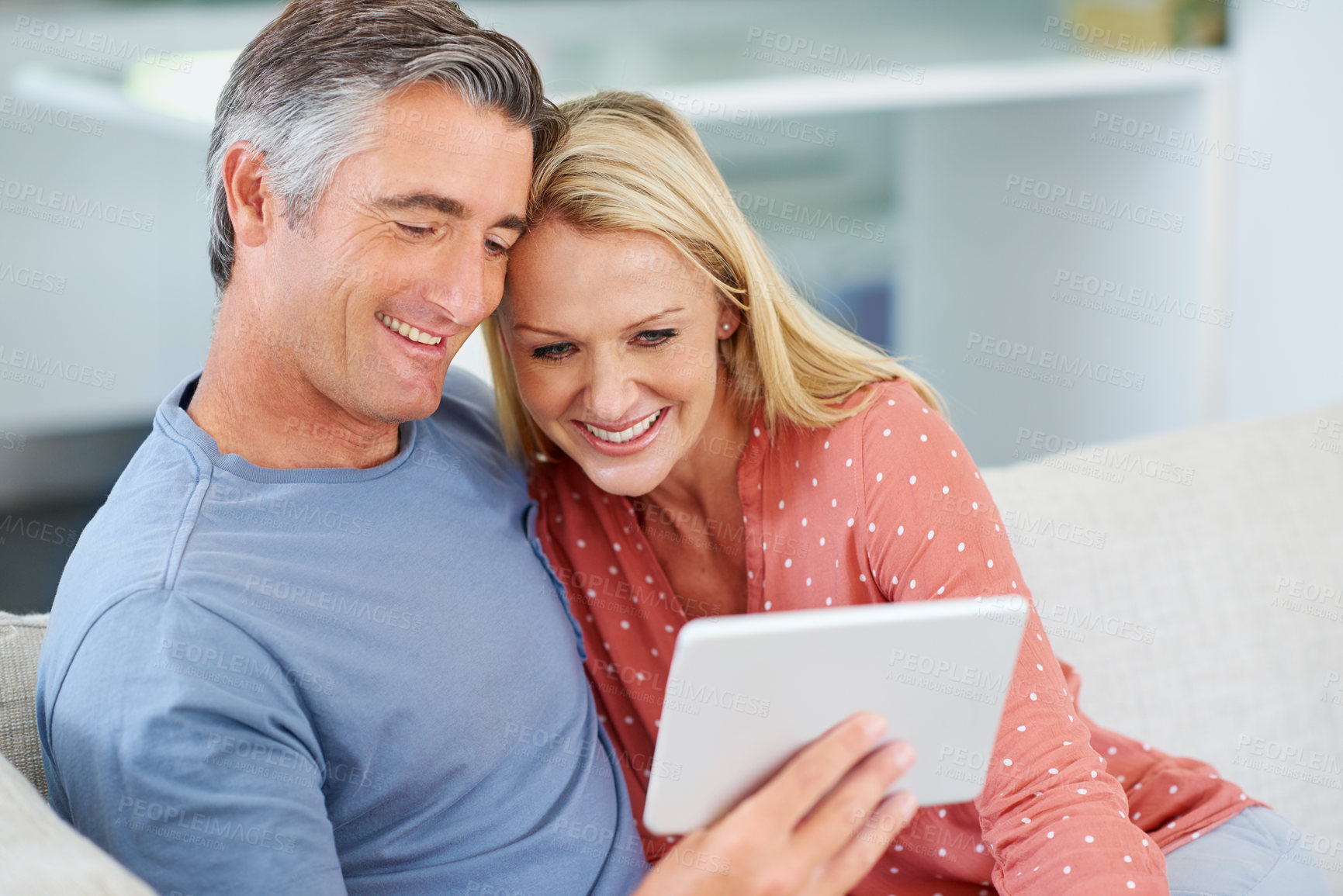 Buy stock photo Shot of a mature couple relaxing with their digital tablet at home