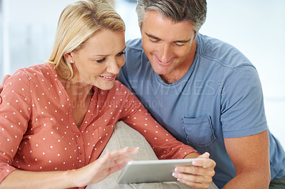 Buy stock photo Shot of a mature couple relaxing with their digital tablet at home