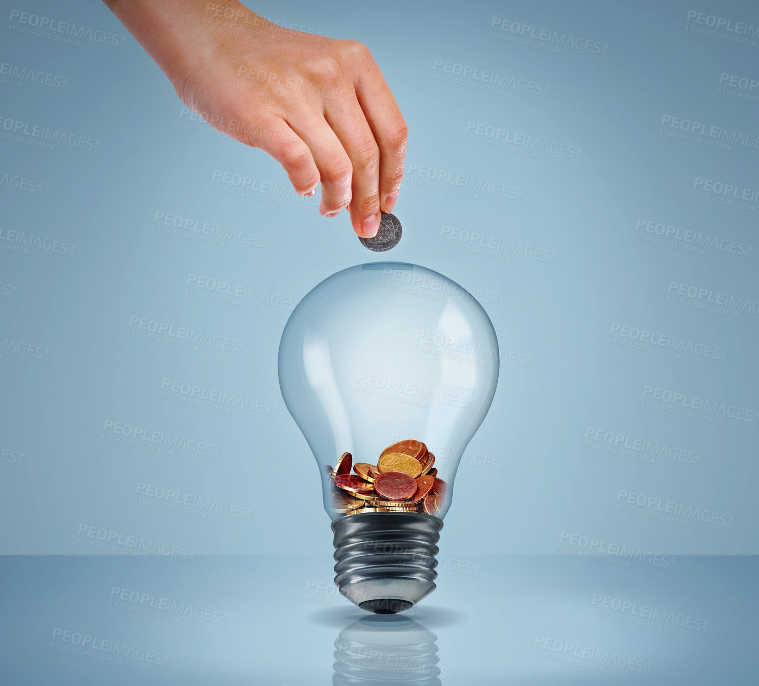 Buy stock photo Studio shot of a woman's hand putting money into a lightbulb