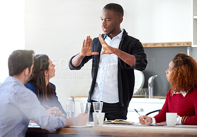 Buy stock photo Cropped shot of a young businessman addressing his colleagues during a business meeting
