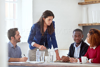 Buy stock photo Cropped shot of a young businesswoman addressing her colleagues during a business meeting
