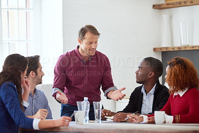 Buy stock photo Cropped shot of a handsome businessman addressing his colleagues during a business meeting