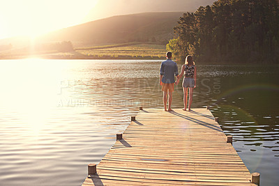 Buy stock photo Back, couple and holding hands at lake for love, sightseeing and travel for anniversary. Summer vacation, man and woman on pier with romantic gesture, relationship development or commitment in nature