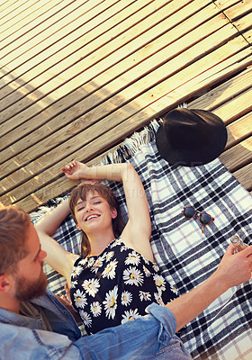 Buy stock photo Outdoor, couple and happy with lying on ground on break with love, rest and affection for care. Above, people and relationship with smile in blanket on valentines day for holiday to relax and bonding