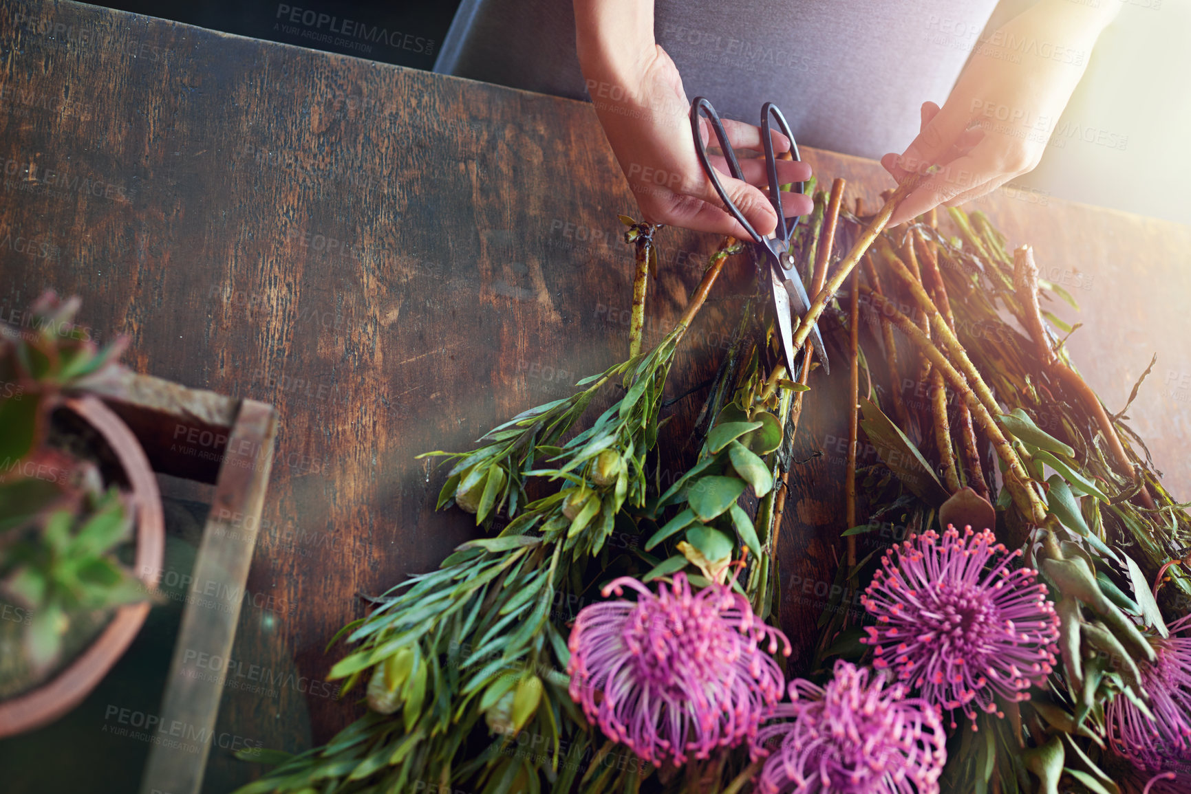 Buy stock photo Cropped shot of a pretty floral bouquet being completed on a wooden counter top
