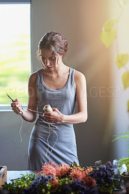 Buy stock photo A young woman in the process of making a flower arrangement