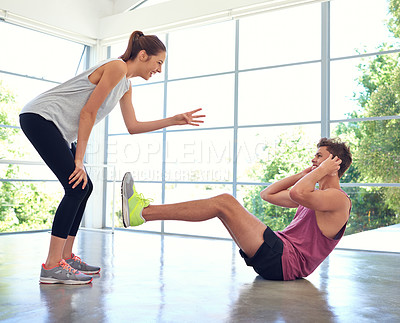 Buy stock photo Shot of an attractive young woman helping her boyfriend through his workout
