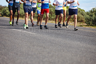 Buy stock photo Cropped shot of a group of men running a marathon