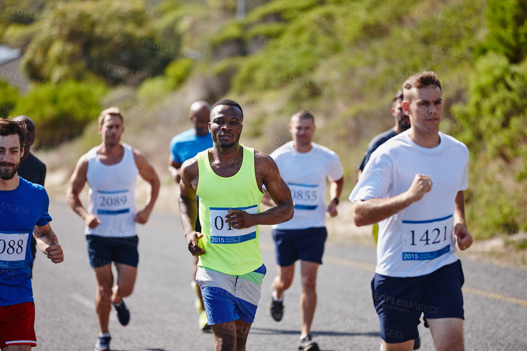 Buy stock photo Shot of a group of young men running a marathon