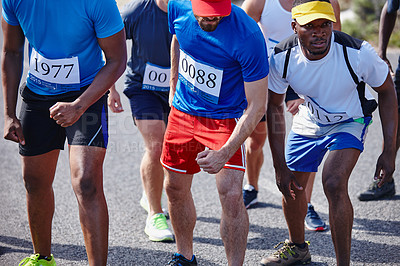 Buy stock photo Shot of a group of young men competing in a marathon