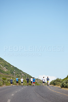 Buy stock photo Rearview shot of a group of men running a marathon