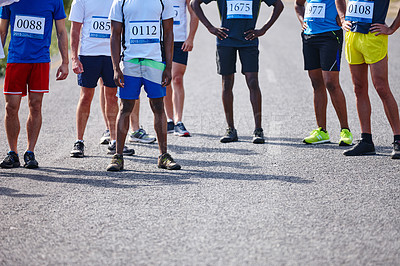 Buy stock photo Shot of a group of young men at the starting point of a marathon