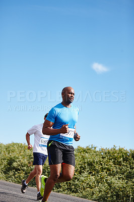 Buy stock photo Shot of a young man running a marathon