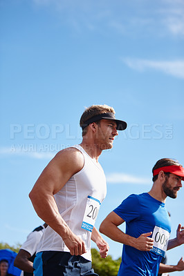 Buy stock photo Shot of young men running a marathon