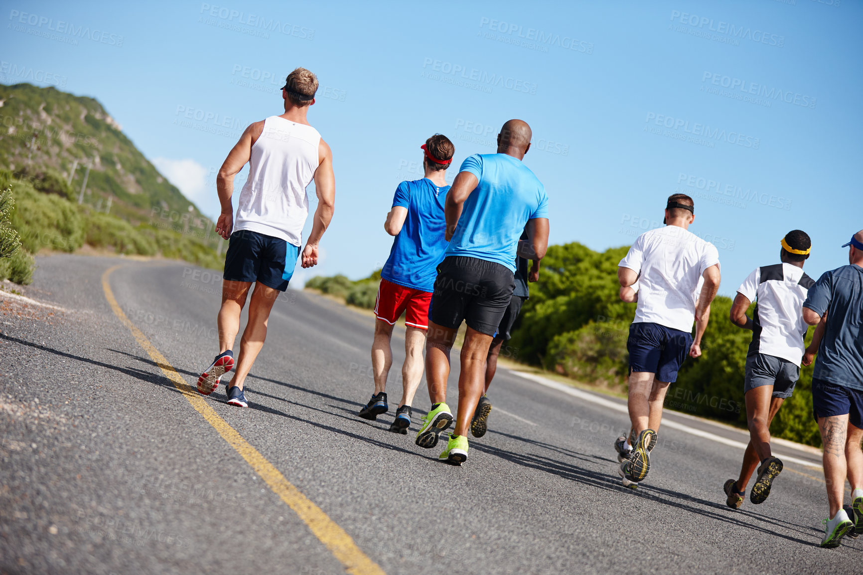 Buy stock photo Rearview shot of a group of men running a marathon