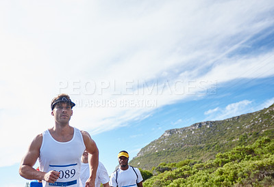 Buy stock photo Shot of a young man running a marathon
