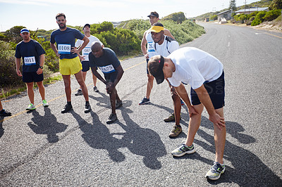 Buy stock photo Shot of a group of male runners getting focused before a road race