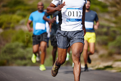 Buy stock photo Cropped shot of a man running ahead of the pack in a marathon